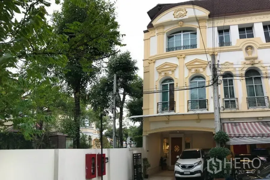 Townhouse for rent or sale in Yan Nawa, Bangkok - European-style three-storey townhouse exterior with covered carport and mature trees.
