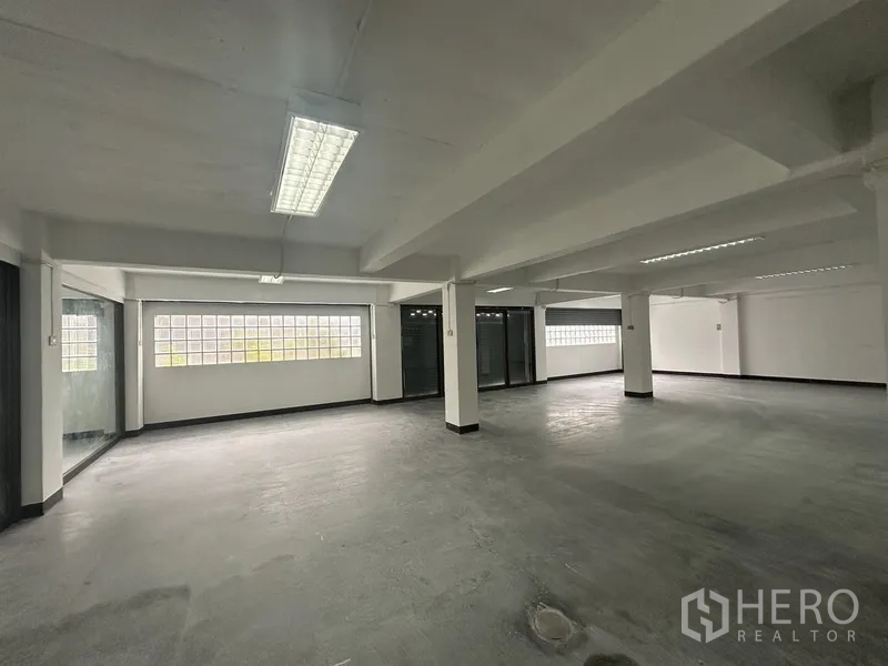 办公空间 出租在Khlong Toei, Bangkok - 宽阔办公地面，混凝土质感、立柱与长条玻璃砖墙