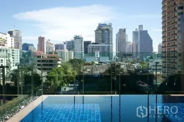公寓 出租或出售在Watthana, Bangkok - 屋顶泳池配玻璃护栏，俯瞰曼谷素坤逸天际线。