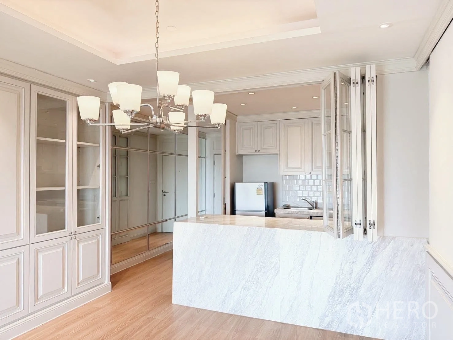 Condominium for rent or sale in Sathon, Bangkok - View toward open kitchen with marble counter and folding windows.