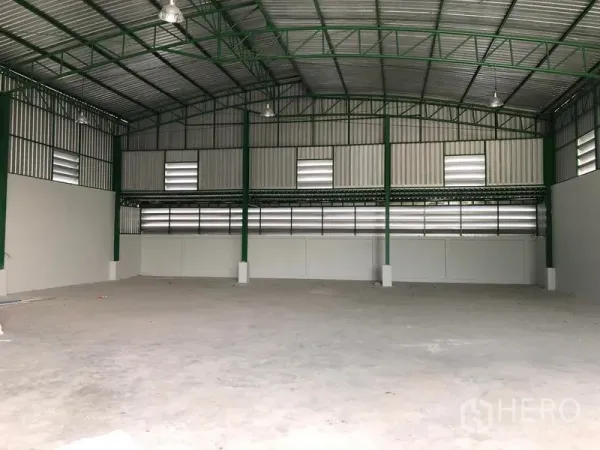 Factory for rent or sale in Khlong Luang, Pathum Thani - Spacious warehouse interior with high ceiling, green steel trusses, and a concrete floor.