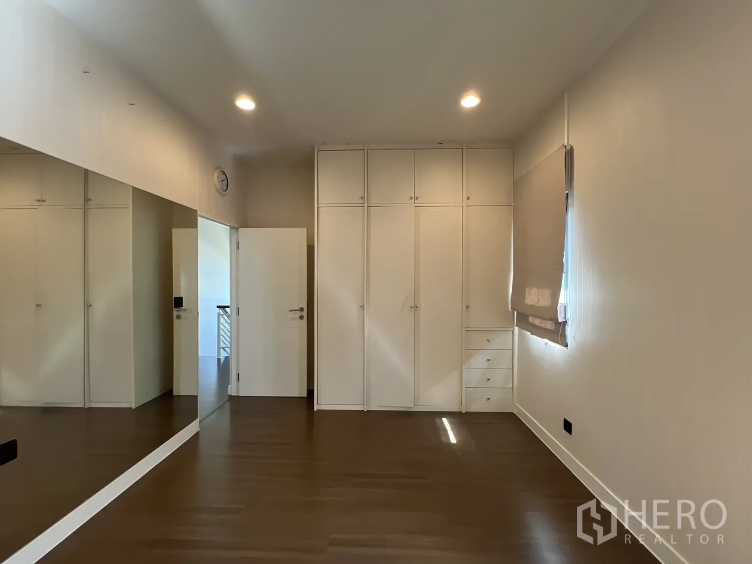 Detached House for sale in Bang Kapi, Bangkok - Mirrored bedroom showing wardrobes and window blinds.