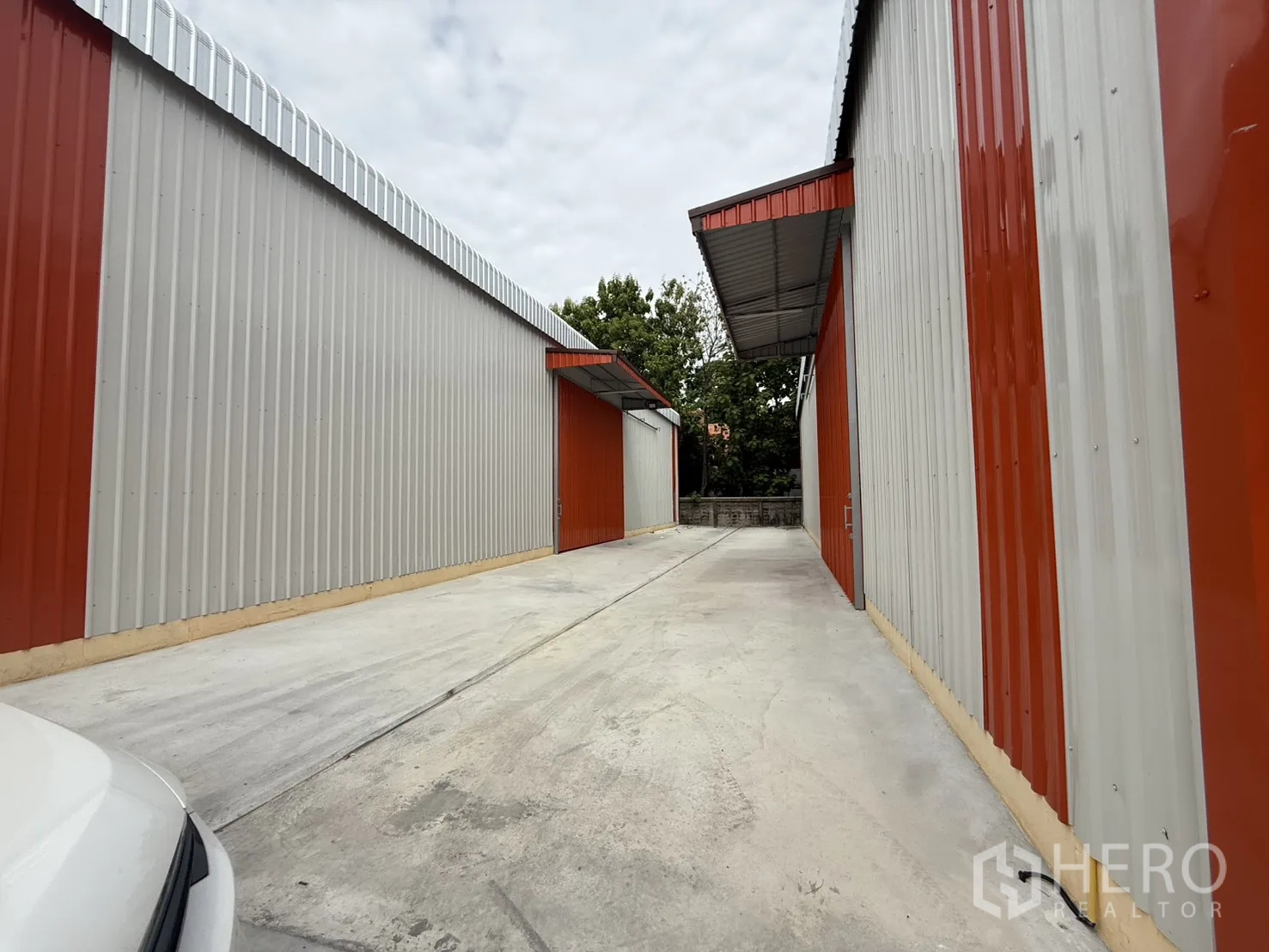 仓库 for rent in Wang Thonglang, Bangkok - 仓库楼间侧向通道，设有雨棚与围墙。