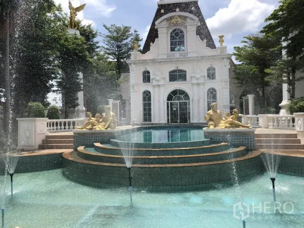 Townhouse for rent or sale in Bang Kapi, Bangkok - Grand community clubhouse with tiered fountain, pool and classical statues within a gated estate.