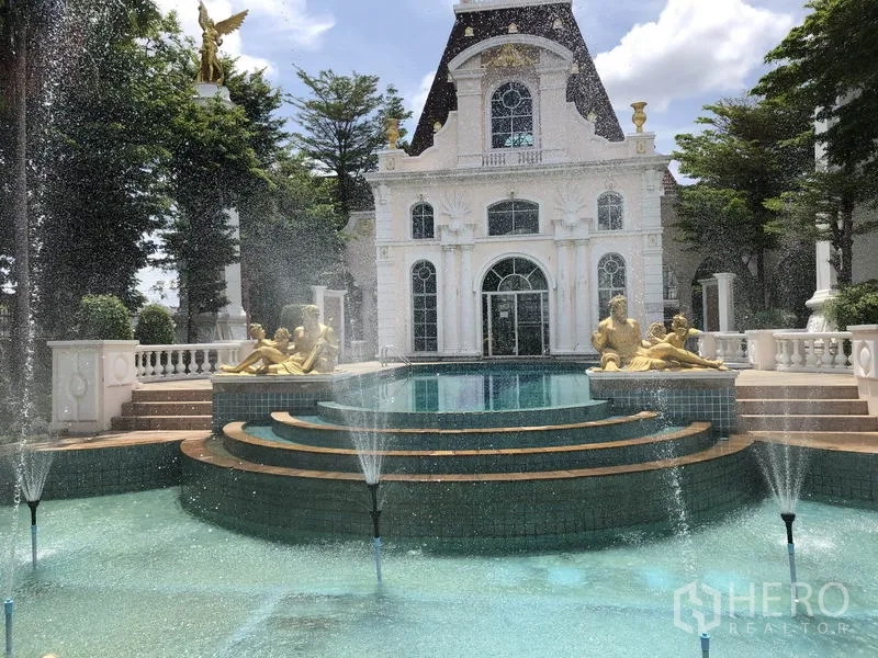 Townhouse for rent or sale in Bang Kapi, Bangkok - Grand community clubhouse with tiered fountain, pool and classical statues within a gated estate.