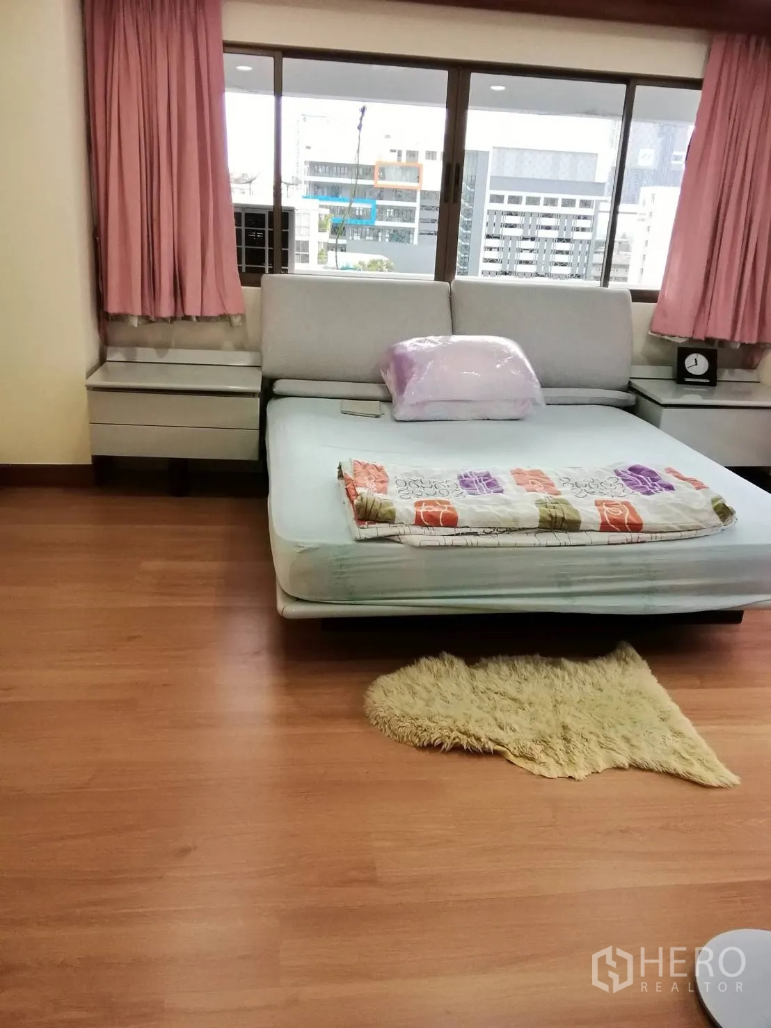公寓 出租或出售在Watthana, Bangkok - 采光明亮的卧室，木地板、粉色窗帘与宽大窗户。