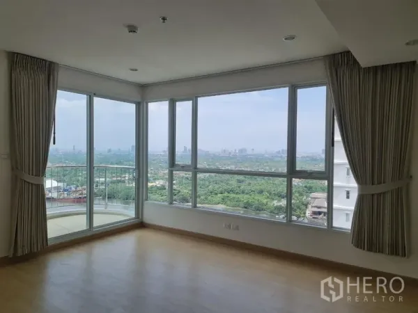 公寓 出售在Yan Nawa, Bangkok - 转角客厅，环绕窗户带来开阔绿意与江景视野。