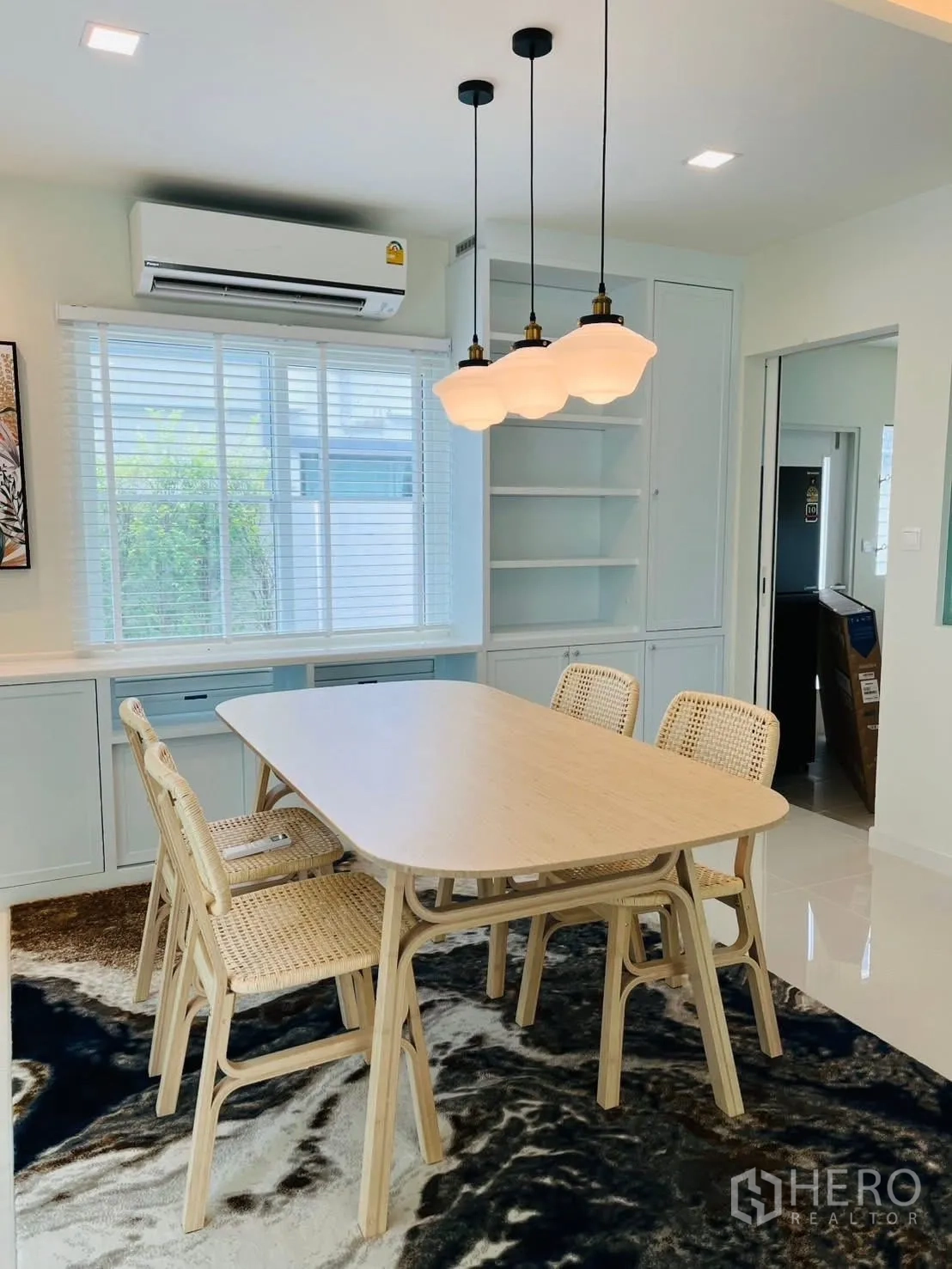 บ้านเดี่ยว for rent in Bang Phli, Samut Prakan - โต๊ะอาหารไม้สีอ่อนพร้อมเก้าอี้หวายสี่ตัวและโคมไฟแขวน.
