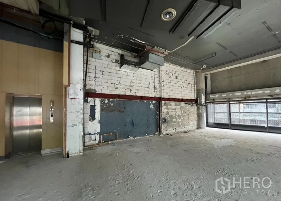 Retail Space for rent - Retail shell space with visible services and lift access at the side wall.