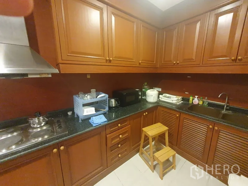 公寓 出租在Bang Kho Laem, Bangkok - 封闭式厨房，木质橱柜，黑色石材台面，灶具与油烟机
