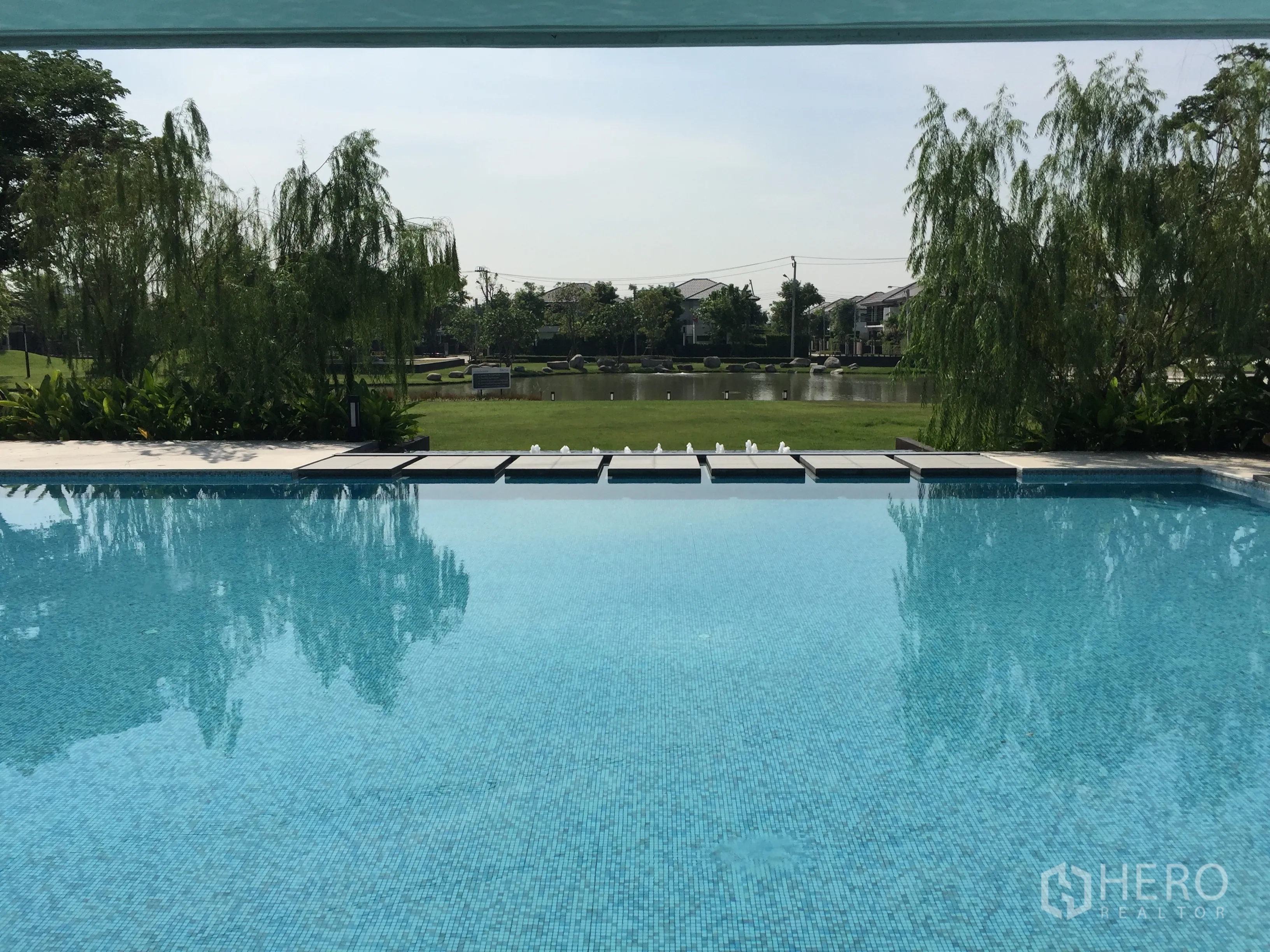 独立式住宅 出租或出售在Prawet, Bangkok - 社区泳池俯瞰湖景与绿地。