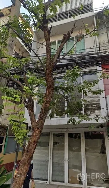 店屋 出售在Watthana, Bangkok - 店屋一层玻璃门店与上层阳台外观，步行可达BTS Phra Khanong。