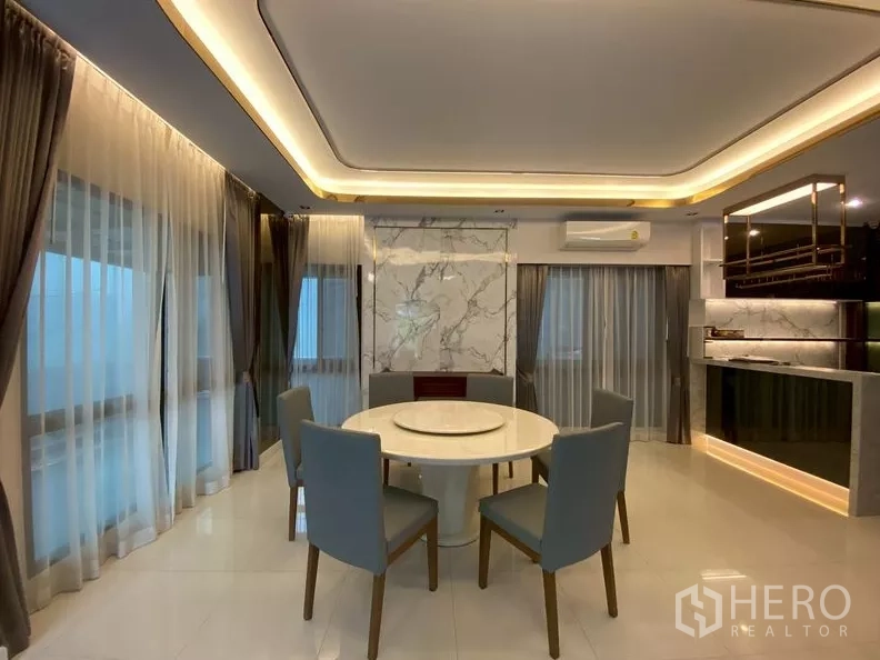 独立式住宅 出租在Prawet, Bangkok - 明亮餐厅，六人圆桌与天花氛围灯。