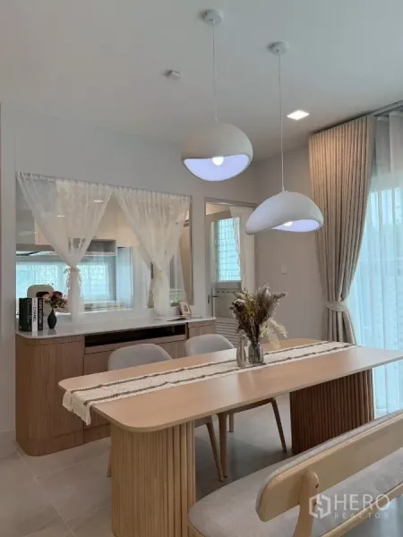 Detached House for rent in Bang Phli, Samut Prakan - Dining nook with wooden table and view into the kitchen through a serving window