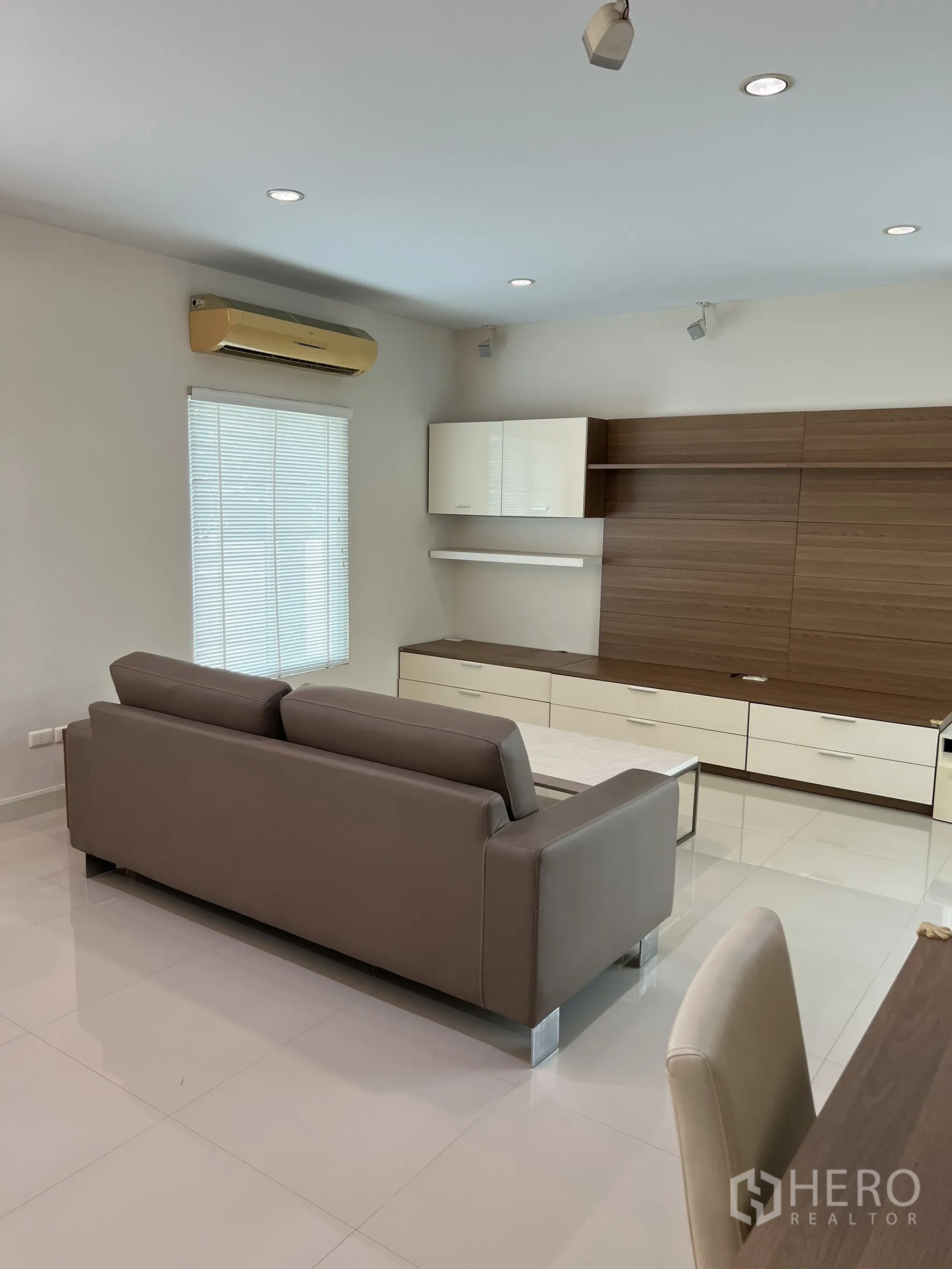 独立式住宅 出租或出售在Saphan Sung, Bangkok - 温馨客厅，灰色沙发与媒体墙，射灯照明。