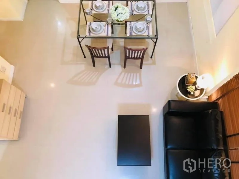 Detached House for rent in Watthana, Bangkok - Top-down view of the open-plan dining and lounge with a set glass dining table and sofa.