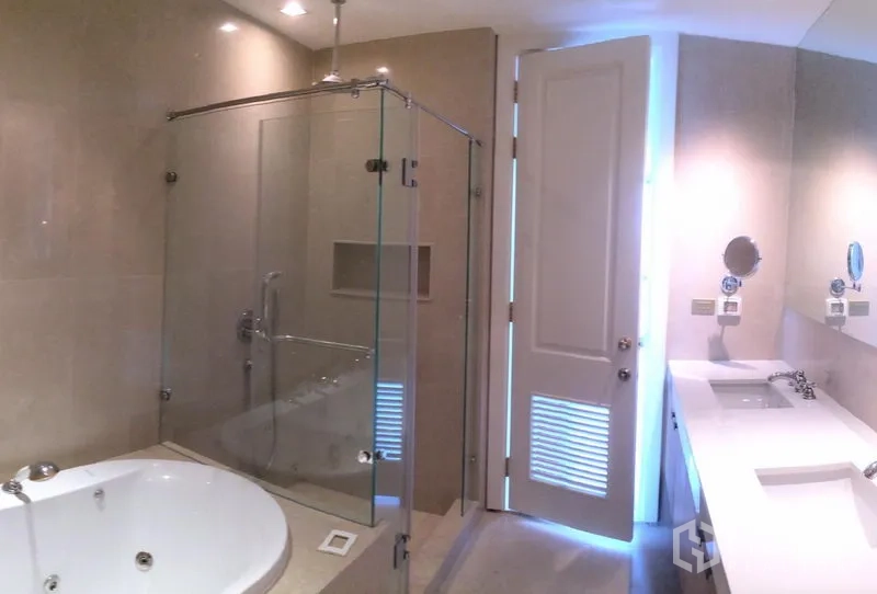 Condominium for rent in Pathum Wan, Bangkok - Modern bathroom featuring a glass-enclosed shower, soaking tub and double-sink vanity.