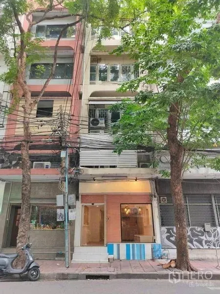 店屋 出租或出售在Bang Rak, Bangkok - 同一店屋的街景外观，门面被成树遮荫。