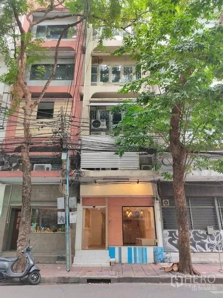 店屋 出租或出售在Bang Rak, Bangkok - 同一店屋的街景外观，门面被成树遮荫。