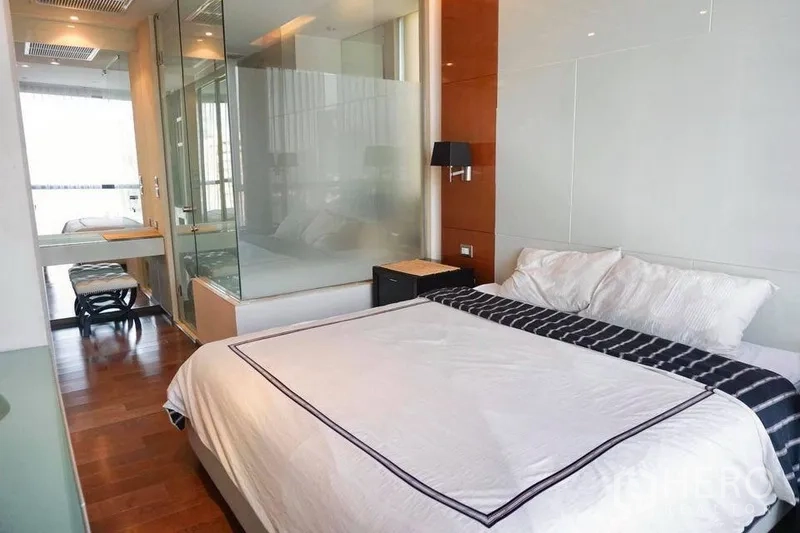 Condominium for rent in Khlong Toei, Bangkok - Bright bedroom with glass-walled ensuite, hardwood floors and built-in lighting in Khlong Toei condo.