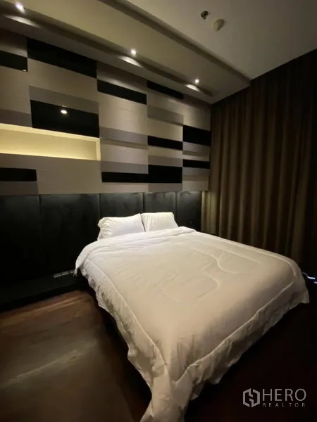 Condominium for rent in Watthana, Bangkok - Second bedroom featuring a geometric feature wall with recessed lighting and dark drapes around a queen bed.