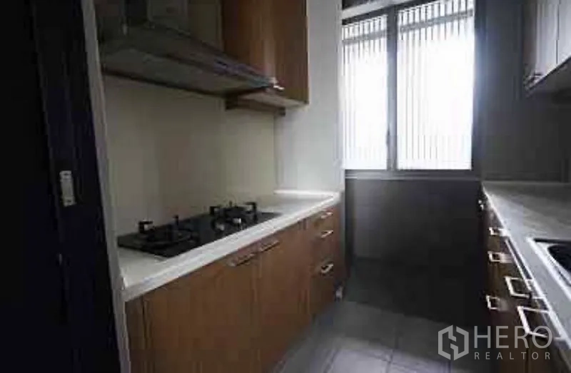 Condominium for rent in Sathon, Bangkok - Separate Thai kitchen with gas hobs, wood cabinets and a window for ventilation.