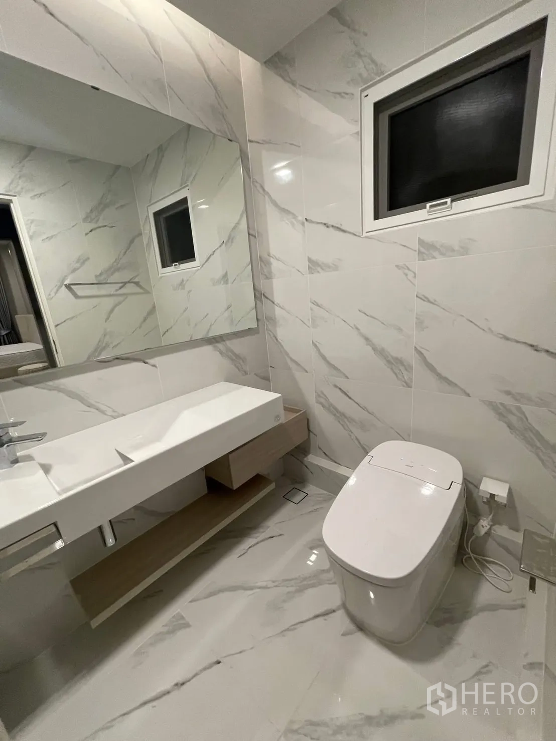 独栋房屋 for rent in Prawet, Bangkok - 浴室铺大理石纹瓷砖，长台盆与现代马桶。