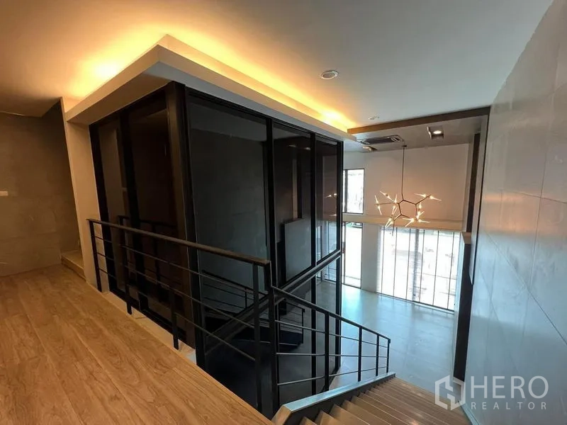 带办公室的家 出租在Bueng Kum, Bangkok - 楼梯平台俯瞰挑高大堂与现代吊灯。