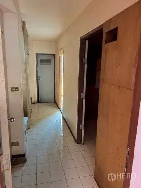 店屋 出租在Watthana, Bangkok - 店屋内走廊，白色地砖与木门，格局方正。