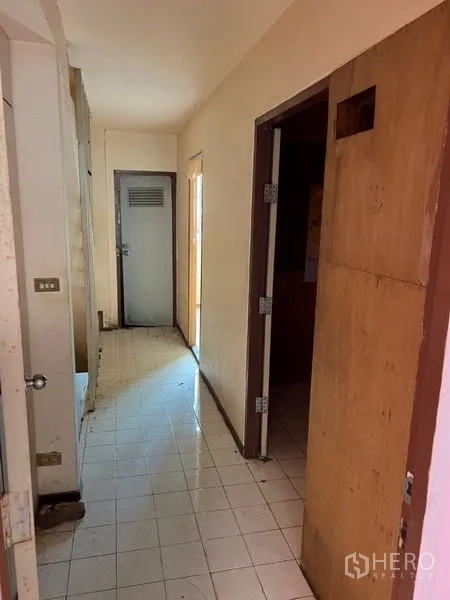 店屋 出租在Watthana, Bangkok - 店屋内走廊，白色地砖与木门，格局方正。
