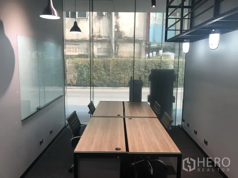 Office Space for rent in Khlong Toei, Bangkok - Meeting-ready office with floor-to-ceiling glass window, whiteboard, two joined desks and task chairs.