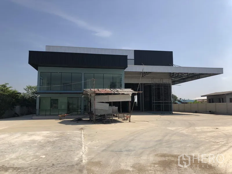 โรงงาน ให้เช่าในLam Luk Ka, Pathum Thani - ด้านหน้าโรงงานสมัยใหม่ในลำลูกกา ปทุมธานี พร้อมออฟฟิศกระจกและลานคอนกรีตกว้าง
