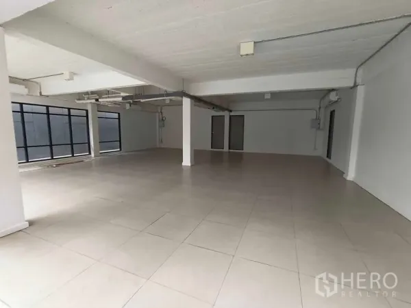 办公空间 出租 - 宽敞的开放式办公室，瓷砖地面，外露管线天花和大面积窗户采光。