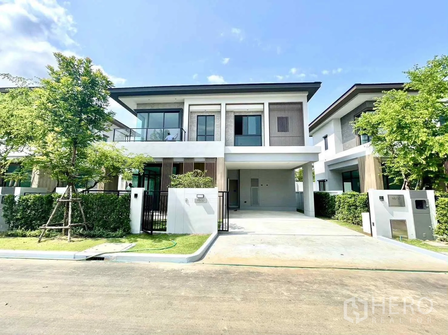 บ้านเดี่ยว for rent in Bang Phli, Samut Prakan - ภาพหน้าบ้านสองชั้นสไตล์โมเดิร์น มีกำแพงรั้ว ระเบียง และที่จอดรถในร่ม.