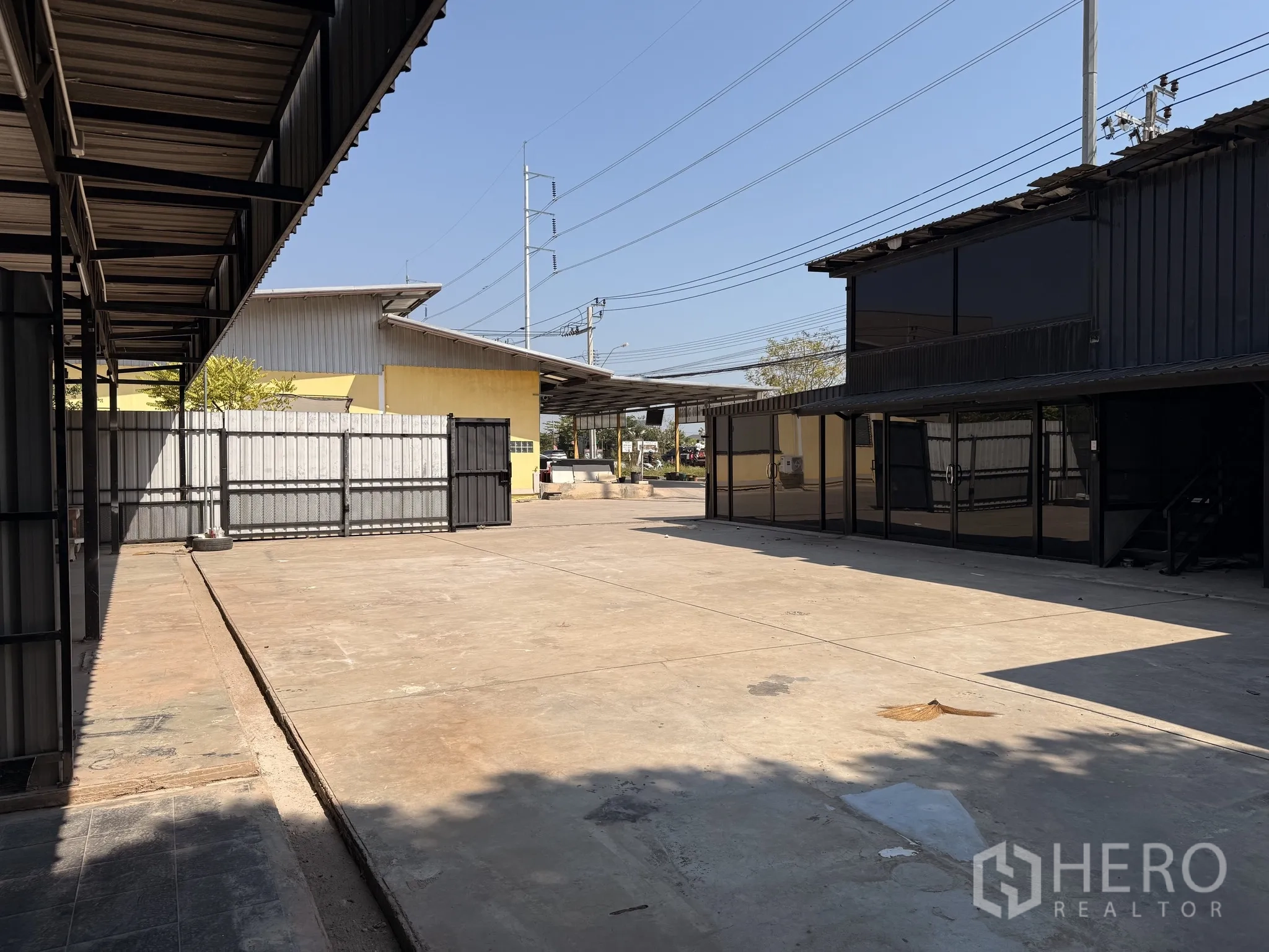 货栈 for rent in Lat Krabang, Bangkok - 宽敞硬化院场，旁有玻璃立面的办公楼与带顶棚作业区。