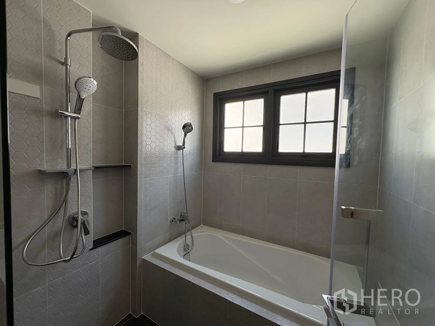 บ้าน for rent in Bang Phli, Samut Prakan - ห้องน้ำพร้อมอ่างอาบน้ำ ฉากกั้นกระจก ฝักบัวเรนชาวเวอร์ และกระเบื้องลายหกเหลี่ยม.