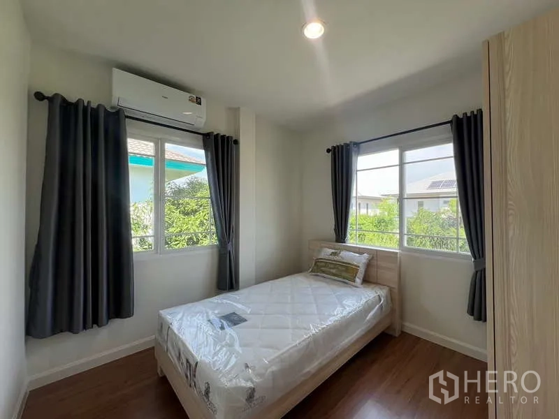 Detached House for rent in Bang Kapi, Bangkok - Third bedroom with single bed, corner windows and greenery views.