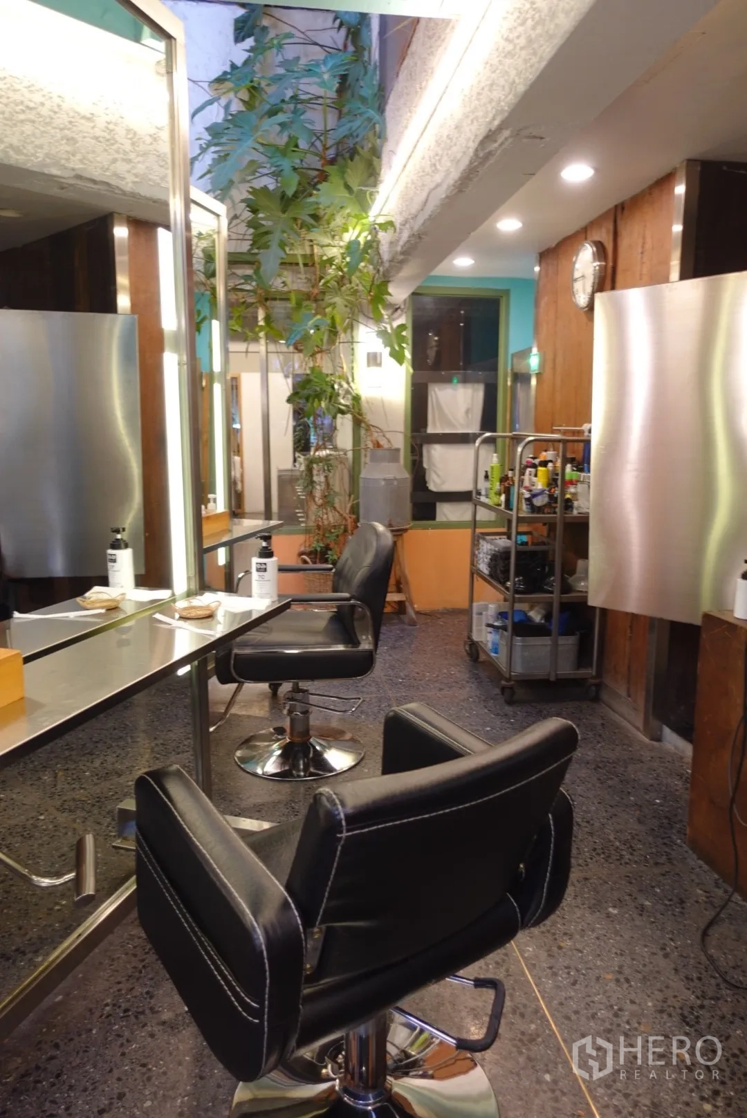 Retail Space for rent in Khlong Toei, Bangkok - Salon-style workstations with mirrors, black chairs and indoor greenery.