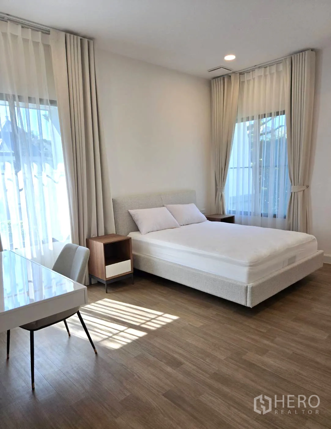 独立式住宅 出租在Saphan Sung, Bangkok - 采光充足的卧室，双人床、书桌与浅色窗帘。