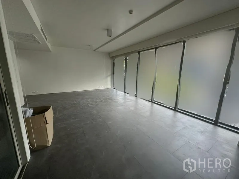 办公空间 出租 - 宽敞工作区，整面落地窗配卷帘，灰色石纹地面。
