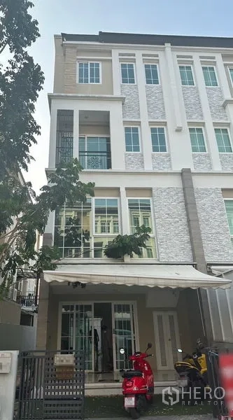 Home Office for rent in Bang Na, Bangkok - Front elevation of the four-storey home office with tree-lined frontage and awning.
