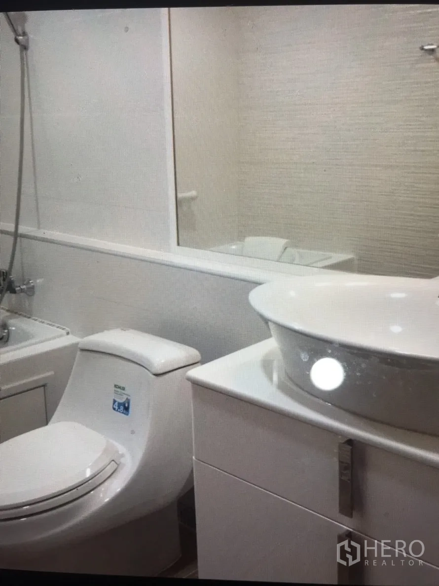 Condominium for rent in Bang Rak, Bangkok - Contemporary bathroom with vessel sink vanity, bathtub with shower and full-width mirror.
