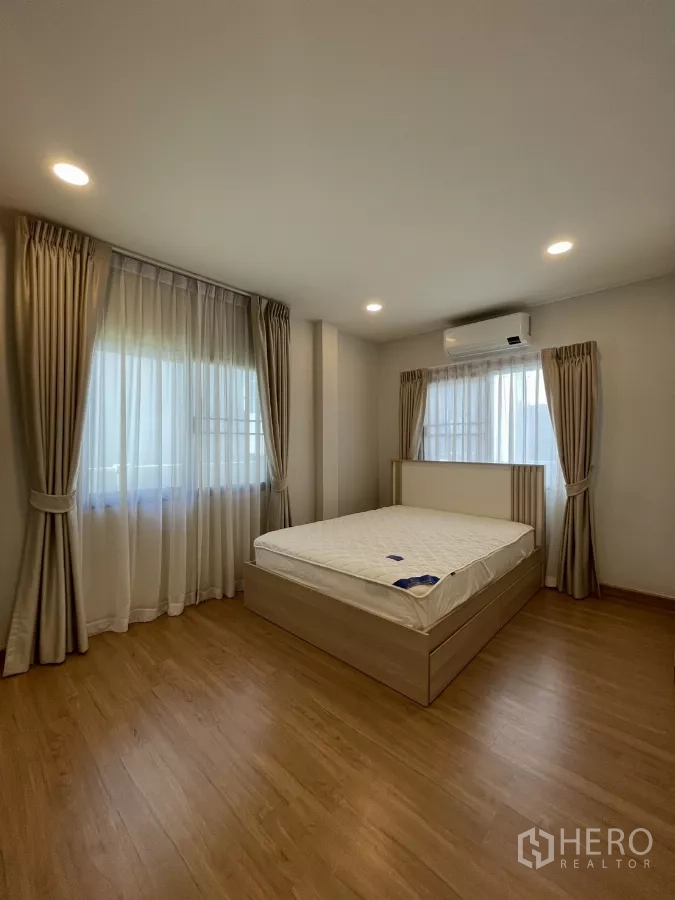 独立式住宅 出租在Bang Phli, Samut Prakan - 第四卧室，木纹床、暖色窗帘与空调。