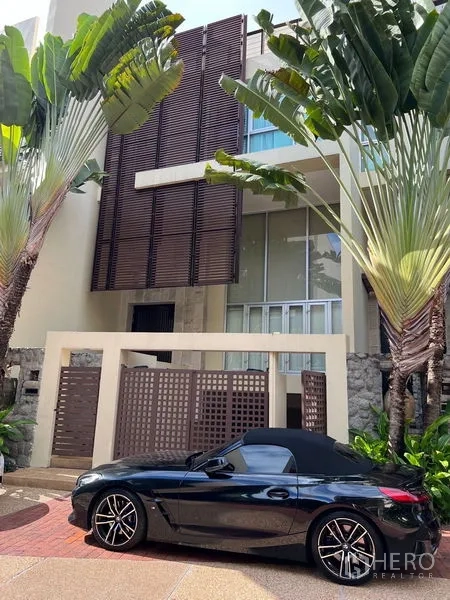 Townhouse for sale in Yan Nawa, Bangkok - Modern townhouse facade with tall wooden screens, gated entry and tropical landscaping
