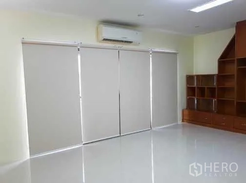 联排别墅 出租在Khlong Toei, Bangkok - 起居区配卷帘、木质嵌入式柜及壁挂空调。