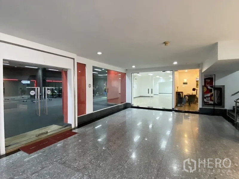 Retail Space for rent in Khlong Toei, Bangkok - Lobby corridor with polished granite floor facing retail units with full-height glass shopfronts.