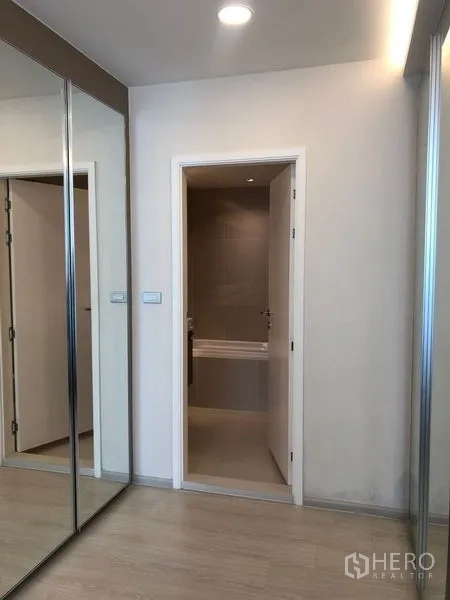 Condominium for sale in Khlong Toei, Bangkok - Hallway with mirrored closets leading into an ensuite bathroom.