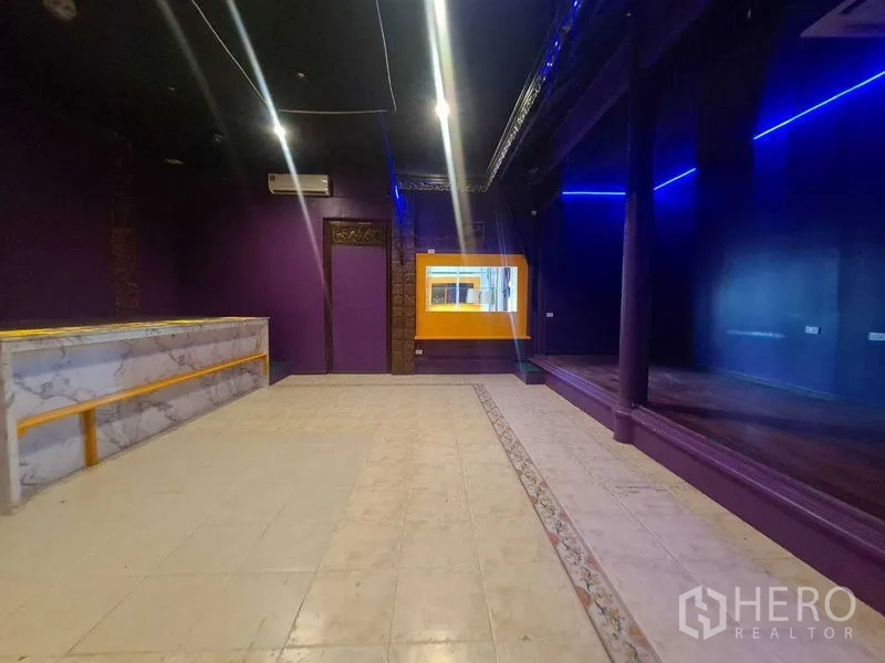 零售空间 出租在Watthana, Bangkok - 主营业厅设大理石服务吧台、舞台式平台与蓝色LED灯带。