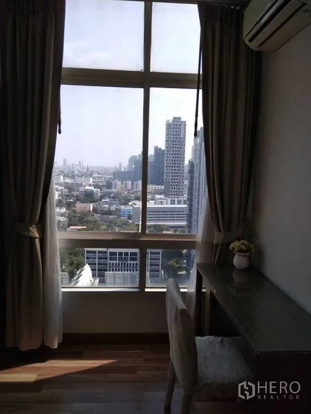 公寓 出租在Watthana, Bangkok - 落地窗旁的书桌，可眺望城市天际线。