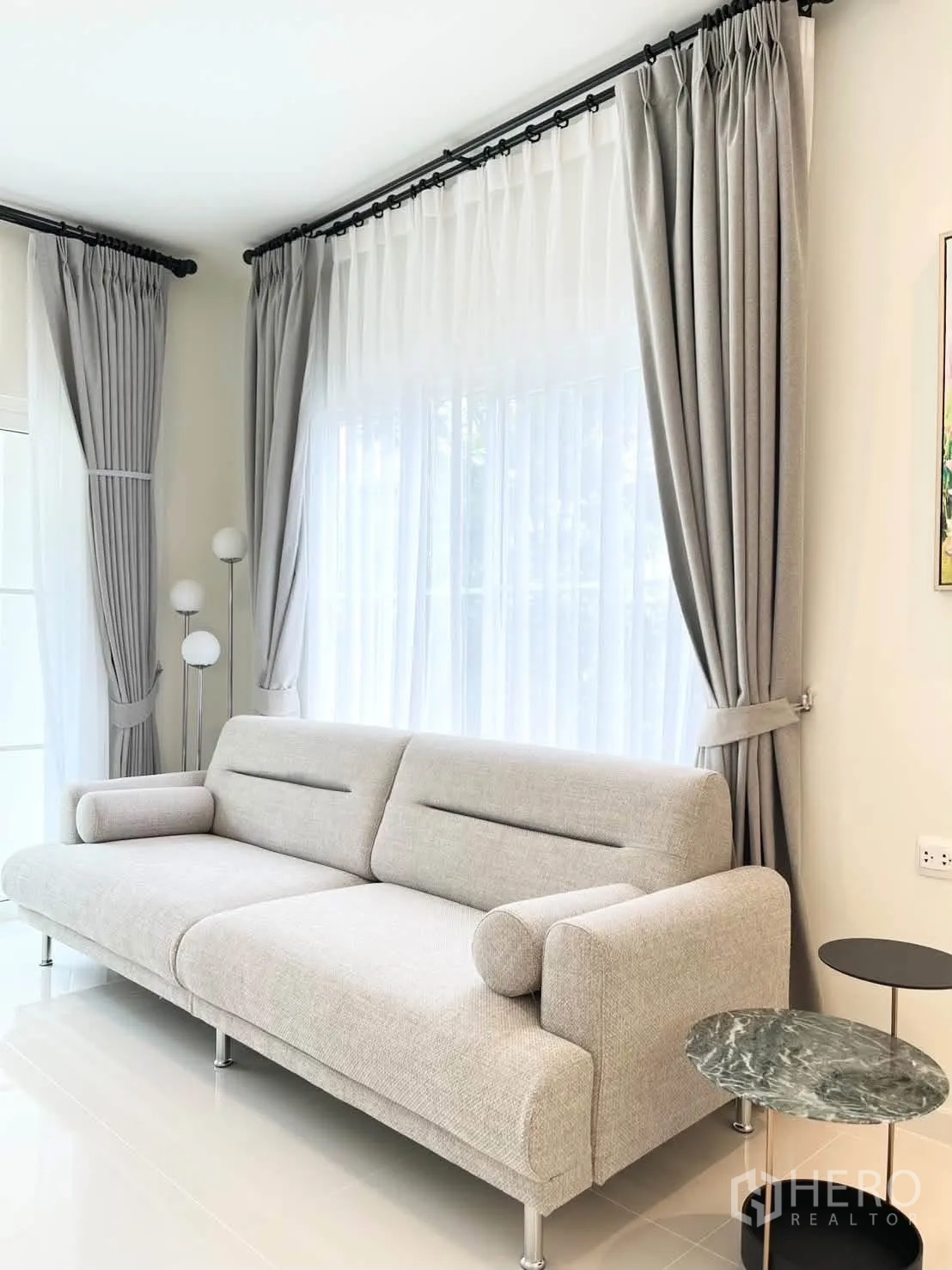 บ้านเดี่ยว for rent in Bang Phli, Samut Prakan - มุมนั่งเล่น โซฟาสีอ่อน ผ้าม่านโปร่ง และโต๊ะข้างทรงกลม